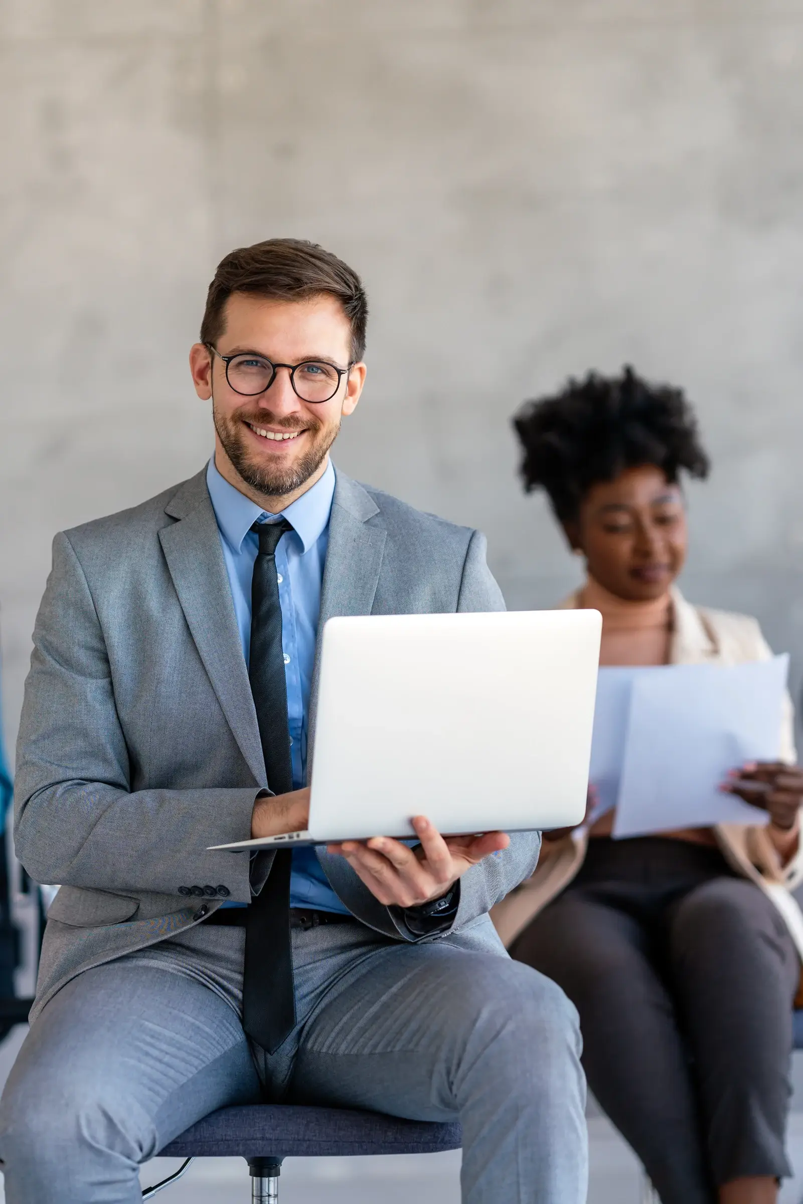 Professionnel souriant tenant un ordinateur portable